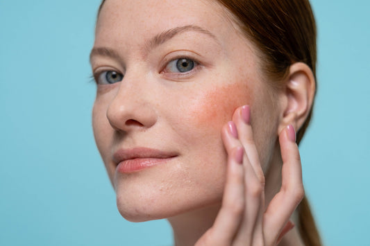 Woman examining dull and uneven facial skin in natural light